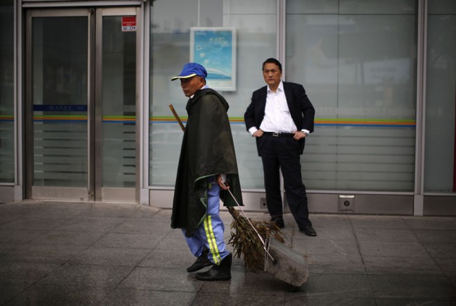Dai Yusheng walks near a shopping mall during a rainy day in Shanghai