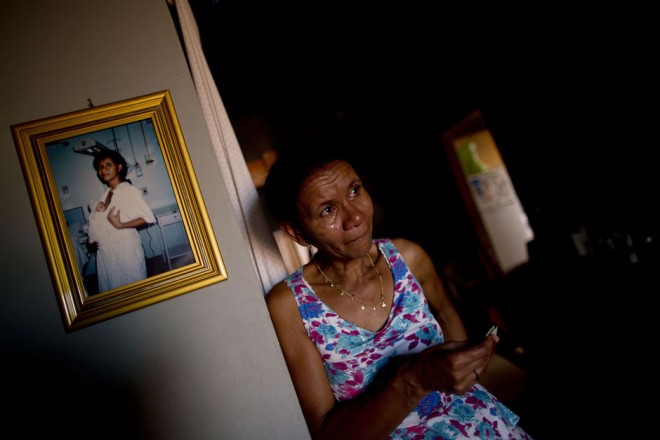 Sueli Paes Alecrin, 48, cries while viewing a monthly bank statement of benefit withdrawals