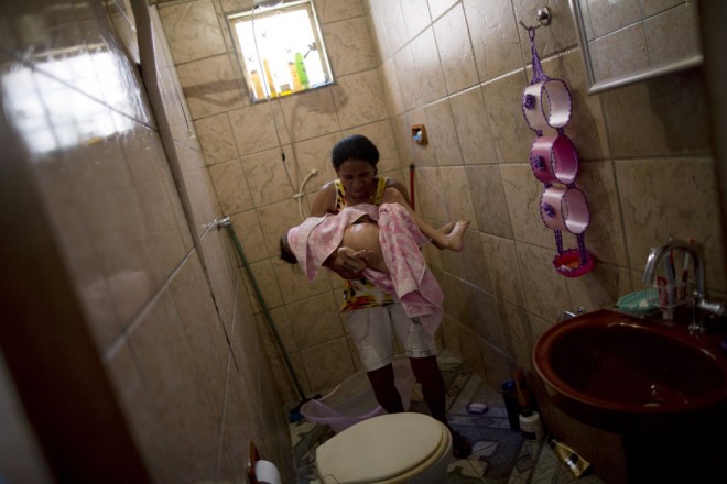 Alecrin towel dries her daughter after a bath in the city of Aguas Lindas